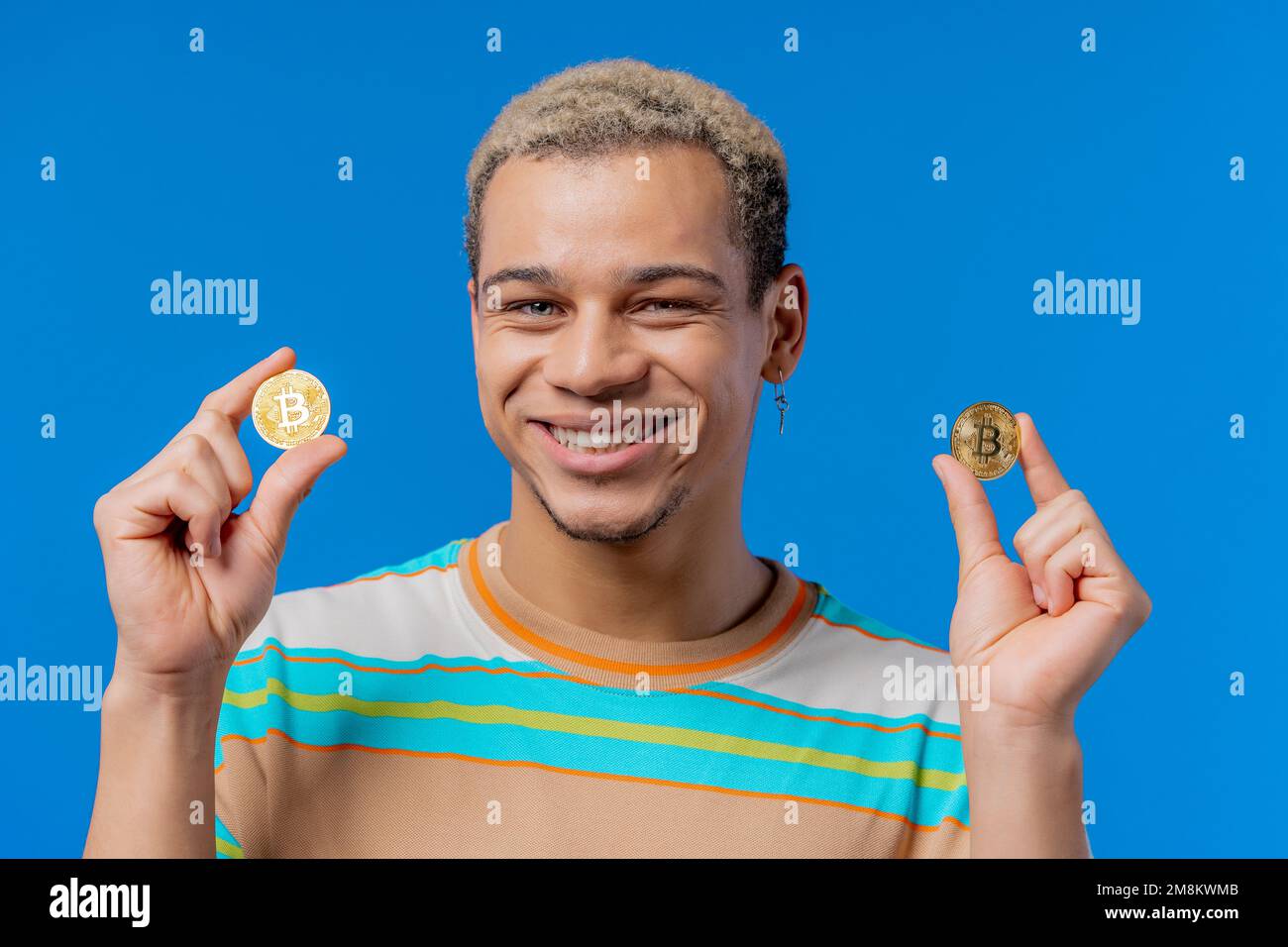 Mann mit Bitcoins, Krypto-Währung. Goldene Münze auf blauem Hintergrund. Digitaler Austausch, Beliebtheit von BTC, Symbol für zukünftiges Geld, Elektronikindustrie Stockfoto