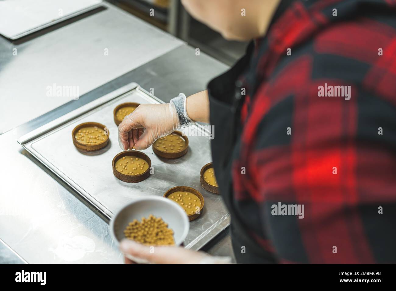 Koch dekoriert kreisförmige Kekse mit goldenen Streuseln und köstlichem Kekskonzept. Hochwertiges Foto Stockfoto