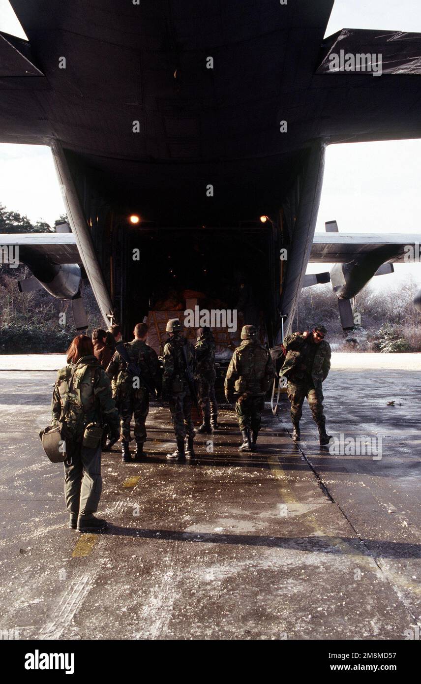 Passagiere und Besatzung entladen ein C-130 Hercules-Flugzeug aus dem 40. Airlift-Geschwader, einer entsandten Einheit vom Dyess Air Force Base, Texas. Die Flüge wurden durch die Winterbedingungen leicht behindert. Die harte Arbeit und das Engagement aller beteiligten Mitarbeiter haben die Ausrüstung und das Personal mit minimaler Verzögerung an ihr Ziel gebracht. Betrifft Operation/Serie: GEMEINSAMER STÜTZPUNKT: Tuzla Luftstützpunkt Land: Bosnien und Herzegowina (BIH) Stockfoto