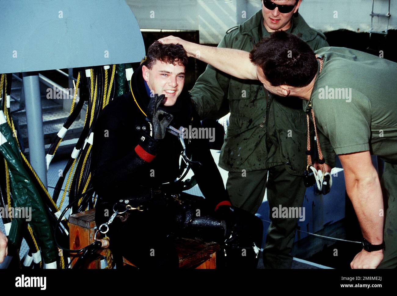 Ein Navy-Taucher, der gerade von einem Übungstauchen zurückkehrt, zeigt das A-OK-Schild an, wenn er beim Auftauchen ausgecheckt wird. Land: Pazifik (POC) Stockfoto