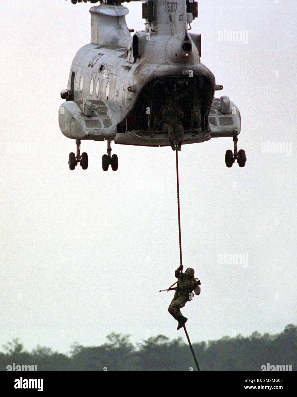 Ein Marine aus dem 3. Bataillon, 2D Marines, schnallt sich aus einem CH-46E Sea Knight Hubschrauber auf ein Dach der MOUT-Anlage (Military Operations in Urban Terrain) in Camp Lejeune, North Carolina. Diese Marines probten für eine Demonstration, die am nächsten Tag im Rahmen der ÜBERPRÜFUNG DER FÄHIGKEITEN stattfinden sollte. Betreff Betrieb/Serie: ÜBERARBEITETE FÄHIGKEITEN Basis: Marinekorps Basis, Camp Lejeune Staat: North Carolina (NC) Land: Vereinigte Staaten von Amerika (USA) Stockfoto