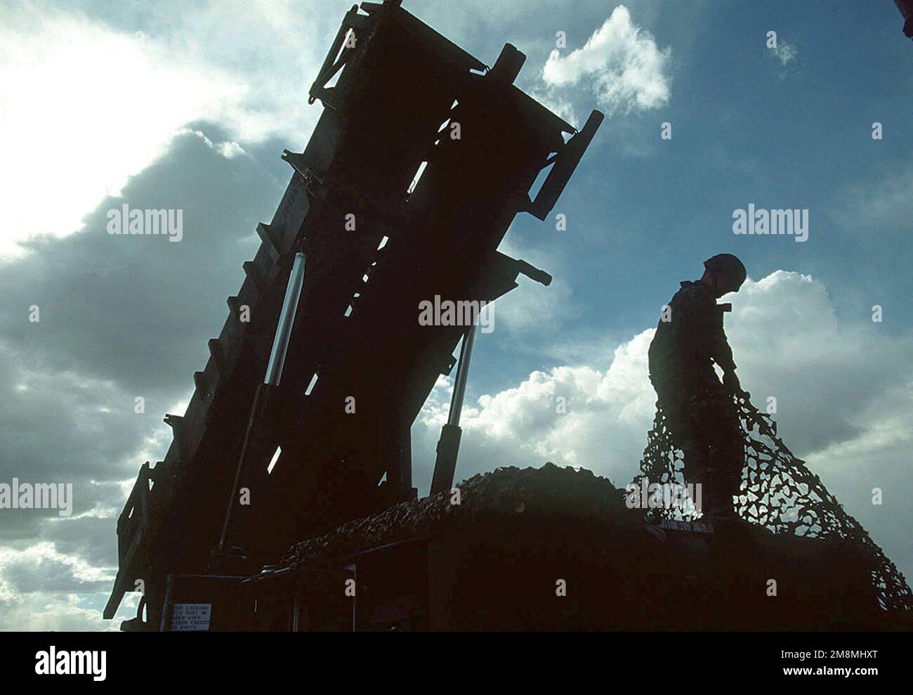 Ein Patriot-Raketen-Crewmitglied, mit der 35. Air Defense Artillery, Fort Lewis, Washington, um die Verdeckung zu verbessern, zieht Tarnnetze über seinen Abschussrampe. Die 35. ADA wird während ihres Einsatzes Patriot Raketenabwehr gegen Angriffe feindlicher Kämpfer und simulierte SCUD-Raketenabschüsse während der weltweit größten gemeinsamen, multinationalen taktischen Flugübung bieten. Betreff Betrieb/Serie: ROVING SANDS '97 Basis: Fort Bliss Bundesstaat: Texas (TX) Land: Vereinigte Staaten von Amerika (USA) Stockfoto