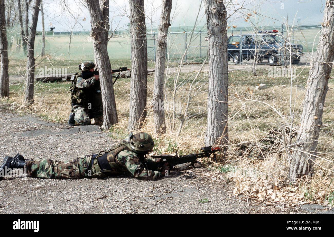 War an einer Übung zur Neuaufnahme der Launch Facility beteiligt, STAFF SGT. Marvin Robey, M-60-Schütze, AIRMAN 1. Klasse Ron Strong und weitere Mitglieder der 10. Raketenstaffel Sicherheitspolizei, nehmen ihre Positionen um den Zaun und die Zufahrtsstraße der eingefangenen Abschusseinrichtungen ein und feuern auf die letzten überlebenden 'Bösen', die sich in der Abschusseinrichtung verstecken und hartnäckig zurückschlagen. Basis: Luftwaffenstützpunkt Malstrom Bundesstaat: Montana (MT) Land: Vereinigte Staaten von Amerika (USA) Stockfoto