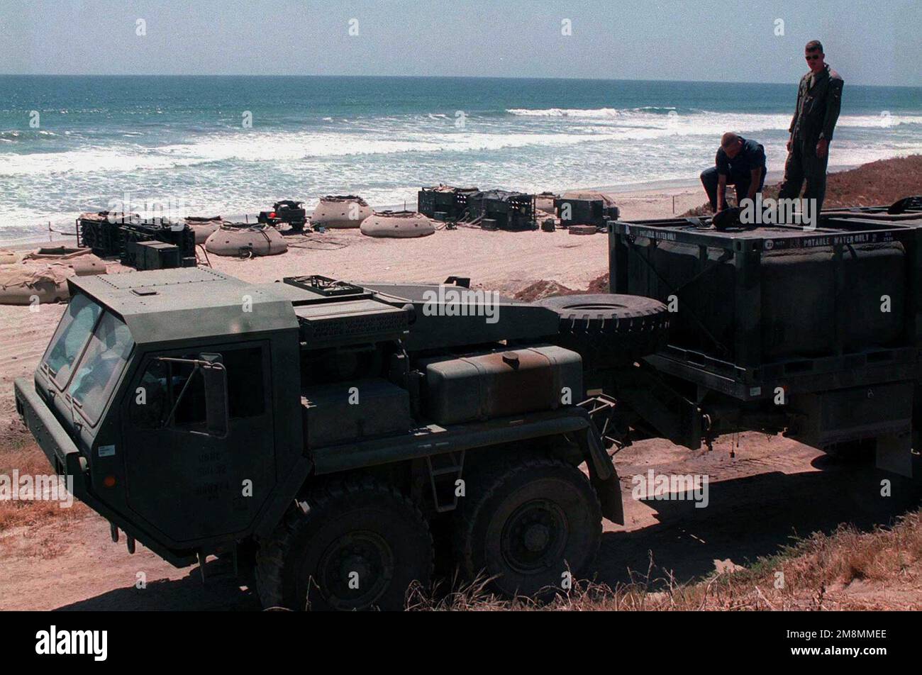 Marines von der Marine Wing Support Squadron (MWSS) 374, Marine Corps Air Station, Tustin, CA, füllen einen Wassertank auf einem Mk48 Logistik Vehicle System (LVS) „Dragon Wagon“ am Red Beach. Die Umkehrosmose-Wasserreinigungsanlage im Hintergrund ist auch Teil von Utilities, MWSS 374, 3. Marine Air Wing, 1. Marine Expeditionary Force. Betreff Operation/Serie: KERNEL BLITZ '97 Base: Marine Corps Base Camp Pendleton Bundesstaat: Kalifornien (CA) Land: Vereinigte Staaten von Amerika (USA) Stockfoto