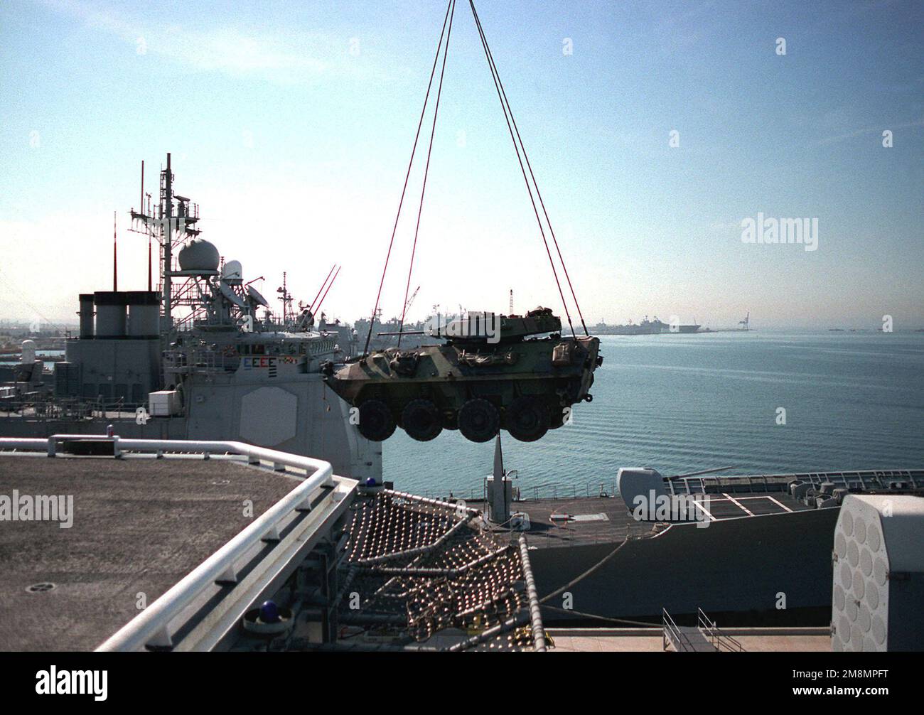 Ein Portalkran hebt ein leicht gepanzertes Fahrzeug-25 (LAV-25) während DES TIEFENSCHLAGS 97 auf die USS TARAWA (LHA-1). Betreff Operation/Serie: DEEP STRIKE '97 Base: San Diego Harbor State: California (CA) Country: United States of America (USA) Stockfoto