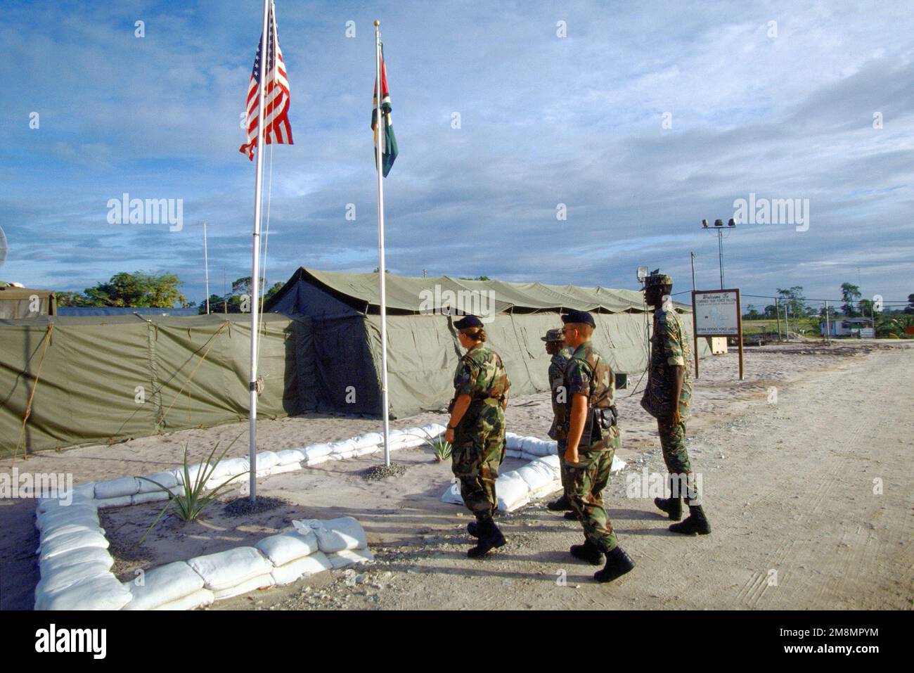 FLIEGER 1. Klasse Chris Stein und STAFF SGT. Denise Watson, Air National Guard Security Forces, 140. Security Forces Squadron, Buckley Field, Colorado. Zusammen mit Sicherheitsexperten der Guyana Defense Force nähern sich die Fahnenstangen im Rahmen der Camp Stephenson Rückzugszeremonien. Die 140. sorgten für die Sicherheit des Lagers, das die Heimat der Falcon-Mitglieder der kombinierten Task Force war, die an der Unterstützung der ersten kombinierten humanitären und zivilen Hilfsaktion zwischen den Vereinigten Staaten und Guyana teilnahmen. Militärpersonal der Air Force, Air Force Reserve & National Guard, Army, A Stockfoto