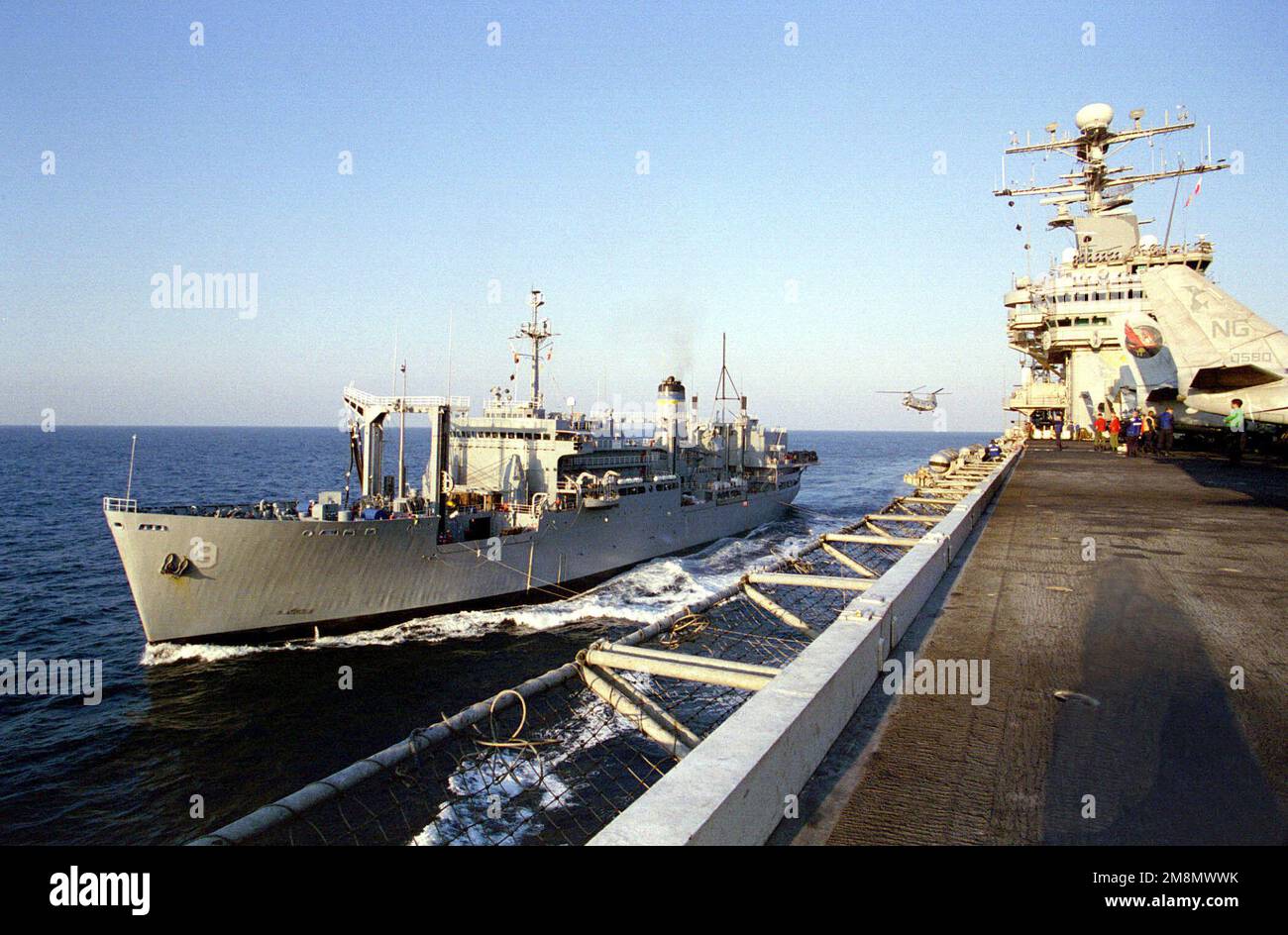 Das militärische Sealift-Kommando (MSC), das Kampfschiff USNS Spica (T-AFS 9), führt an der Seite des nuklearbetriebenen Flugzeugträgers USS NIMITZ (CVN 68) zur Wiederauffüllung von Ausrüstung und Vorräten entlang. Die US-Streitkräfte beobachten weiterhin die Region am Persischen Golf, während sie UN-Sanktionen gegen den Irak durchsetzen. Operation SÜDWACHE, 25. November 1997. Betreff Betrieb/Serie: SÜDLICHE WACHSTATION: USS Nimitz (CVN 68) Stockfoto