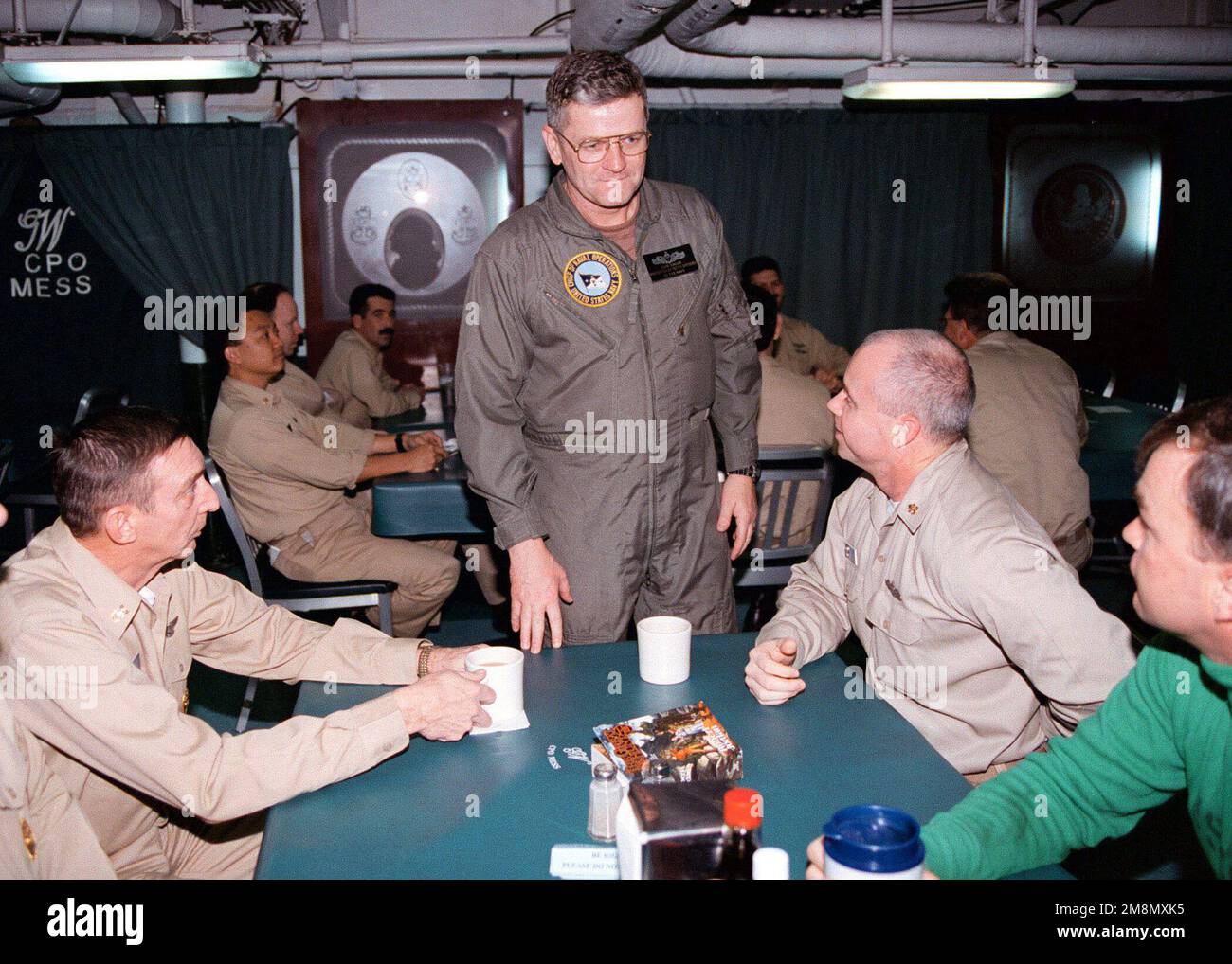 MASTER CHIEF PETTY Officer of the Navy (MCPON) MASTER CHIEF Electronics Technician John Hagen (Center) spricht mit Mitgliedern der USS GEORGE WASHINGTON (CVN 73) CHIEF PETTY Officer's Chaos als Teil der offiziellen Partei DES CHIEF of Naval Operation (CNO), die im Persischen Golf nach vorne entsandte Matrosen und Marines bereist. George Washington und Carrier Air Wing One führen derzeit Operationen zur Unterstützung der UN-Sanktionen gegen den Irak durch, die unter der Operation SOUTHERN WATCH durchgeführt werden. Betreff Betrieb/Serie: SÜDLICHE WACHSTATION: USS George Washington (CVN 73) Stockfoto