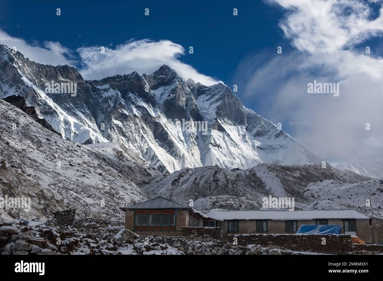 Berghaus im Schnee unter der senkrechten Mauer des Lhotse-Gebirges. Haus in verschneiten Bergen auf dem Everest Base Camp Trek. Touristenloge in Chukhung, Sagarmatha Stockfoto