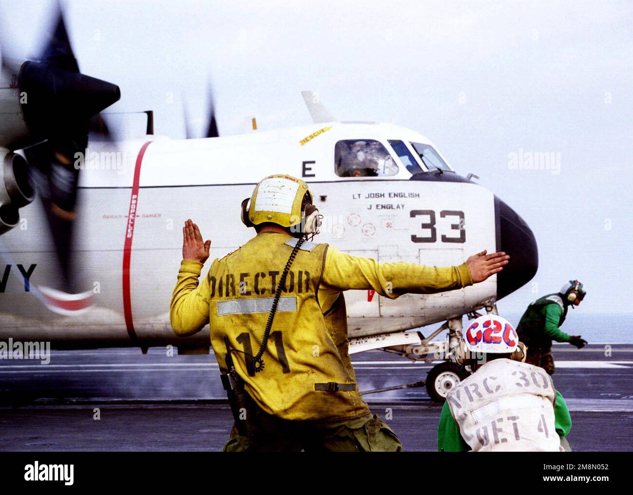 Aviation Boatswains Mate 3. Class Corey Vogel (Center) erteilt dem Piloten einer auf dem Luftfrachtunternehmen ansässigen Airborne Early Warning E-2C Hawkeye vor dem Start vom Cockpit des Flugzeugträgers USS NIMITZ (CVN 68) letzte Anweisungen. Nimitz und ihr an Bord gekommener Carrier Air Wing Nine (CVW9) werden erneut in den Persischen Golf entsandt, um die UN-Sanktionen im Irak zu unterstützen. Basis: USS Nimitz (CVN 68) Stockfoto