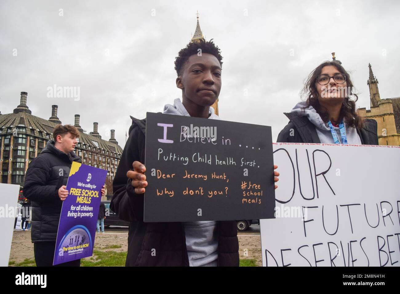 London, Großbritannien. 14. Januar 2023. Eine Schülerin hält während der Kundgebung am Parlamentsplatz ein Plakat mit der Aufschrift „Ich glaube an die Kindergesundheit“. Schulkinder versammelten sich in Westminster zu einer Kundgebung, inszeniert von der gemeinnützigen Organisation Bite Back 2030, die Jeremy Hunt, den Schatzkanzler, aufforderte, allen in Armut lebenden Kindern kostenlose Schulmahlzeiten zur Verfügung zu stellen. Die Organisation reichte dann eine Petition an die Downing Street 10 ein, die von über 250.000 Personen unterzeichnet wurde. Kredit: SOPA Images Limited/Alamy Live News Stockfoto