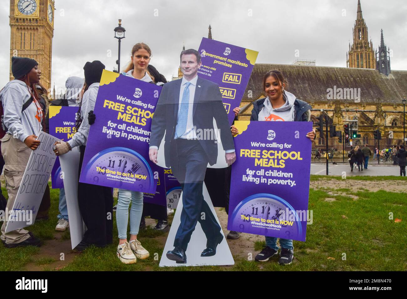 London, Großbritannien. 14. Januar 2023. Die Schüler halten während der Rallye am Parliament Square Plakate für kostenlose Schulmahlzeiten und einen Pappausschnitt von Jeremy Hunt. Schulkinder versammelten sich in Westminster zu einer Kundgebung, inszeniert von der gemeinnützigen Organisation Bite Back 2030, die Jeremy Hunt, den Schatzkanzler, aufforderte, allen in Armut lebenden Kindern kostenlose Schulmahlzeiten zur Verfügung zu stellen. Die Organisation reichte dann eine Petition an die Downing Street 10 ein, die von über 250.000 Personen unterzeichnet wurde. (Foto: Vuk Valcic/SOPA Images/Sipa USA) Guthaben: SIPA USA/Alamy Live News Stockfoto