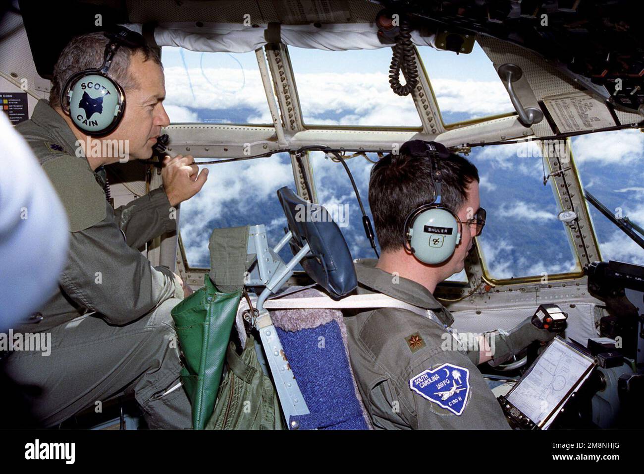 Major Z. B. „Buck“ Shuler, ein C-130 Hercules-Pilot für den 169. Operations Support Flight (OSF), beginnt den Abstieg in den Luftwaffenstützpunkt Soto Cano in Honduras, während Oberstleutnant Scott Cain, der 169. OSF Commander, sich auf die Lokalisierung der Landebahn konzentriert. Der 169. OSF ist dem 169. Kampfflügel der McEntire Air National Guard Station in South Carolina zugeteilt. Während dieser fünftägigen Mission unternimmt diese Crew zwei Ausflüge nach Soto Cano ab, Honduras. Sie liefern dringend benötigte Wasseraufbereitungseinheiten, Nahrungsmittel und medizinische Hilfsgüter, um den von den Folgen des Hurrikanes MITC betroffenen örtlichen Zivilisten zu helfen Stockfoto
