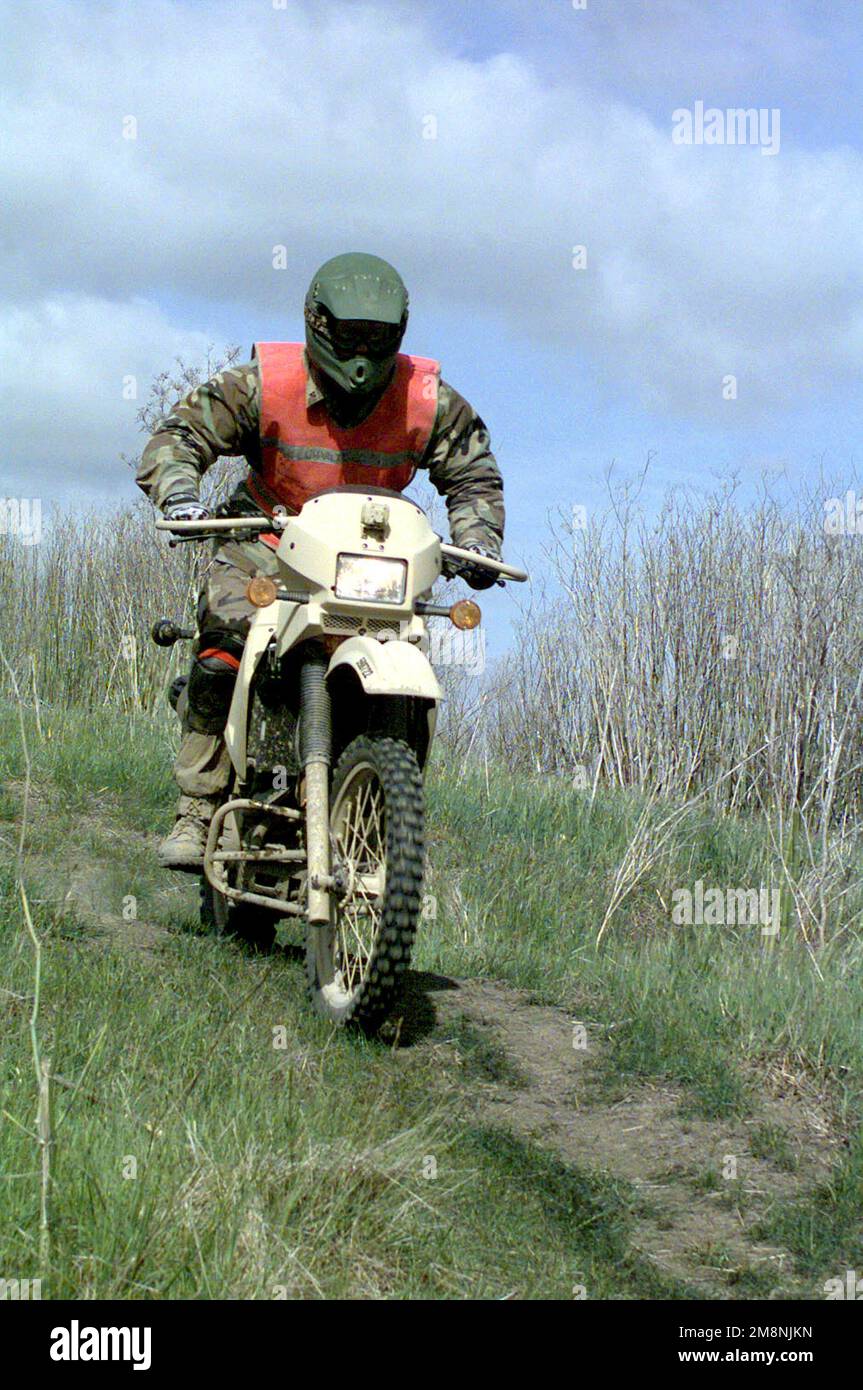 Nach einer scharfen Kurve fährt ein Marine während des Militärmortorcycle Replacement Test beim Motorcycle Training Course im Camp Pendleton, Kalifornien, bergab. Die US Marine fährt in Richtung Kamera, auf einer scheinbar neuen oder aktualisierten Version des KLR-2250 Motorrads. Basis: Marine Corps Basislager Pendleton Bundesstaat: Kalifornien (CA) Land: Vereinigte Staaten von Amerika (USA) Stockfoto