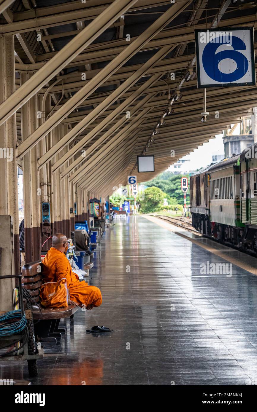 Der Mönch wartet auf einen Zug an Bahnsteig 6 im Bahnhof Hua Lamphong, Bangkok, Thailand Stockfoto