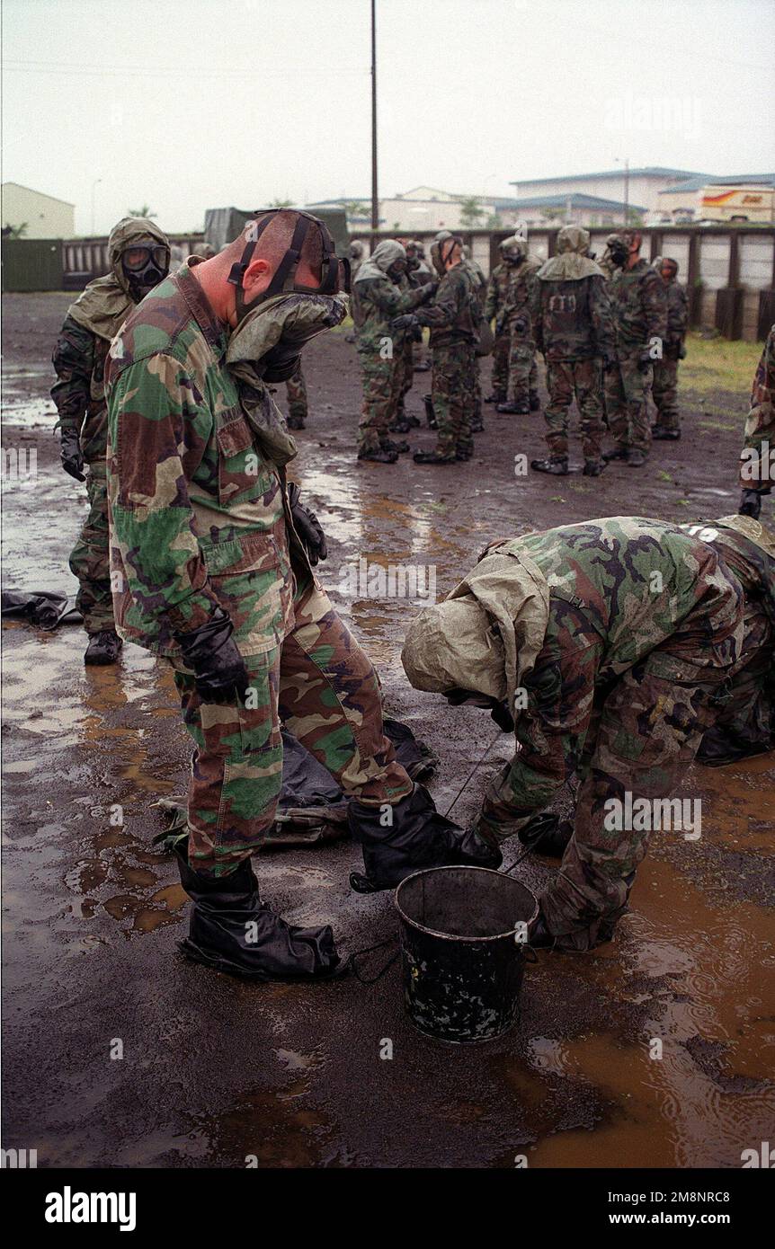 Marines aus India Battery, 3. Bataillon, 12. Marines, Twenty-Nine Palms, Kalifornien, Arbeiten Sie bei der Dekontaminierung ihrer Mission-Oriented Protective Hure Response Level 4 (MOPP-4)-Ausrüstung während nuklearer, bilologischer, chemischer (NBC) Trainingstätigkeiten in einem Camp nahe dem Fuji zusammen. Basis: Berg Fuji Land: Japan (JPN) Stockfoto