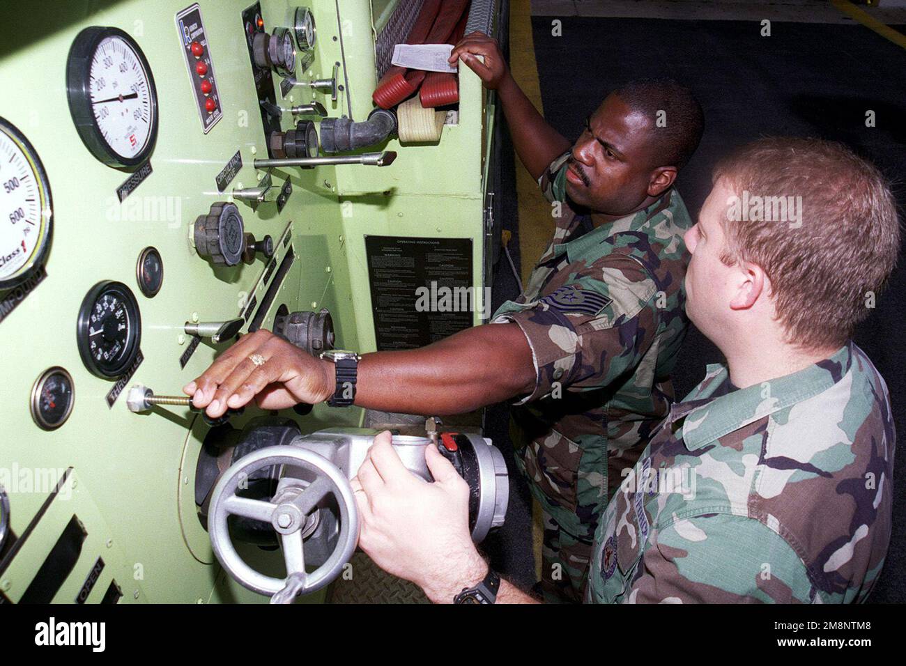 Technischer Sergeant Alfonso Iceman (links) und STAFF Sergeant John Rhoades (rechts) 169. Kampfflugzeug, South Carolina Air National Guard, Überprüfung der Feuerlöschausrüstung vor ihrer Schicht, 26. Juli 1999. Land: Unbekannt Stockfoto