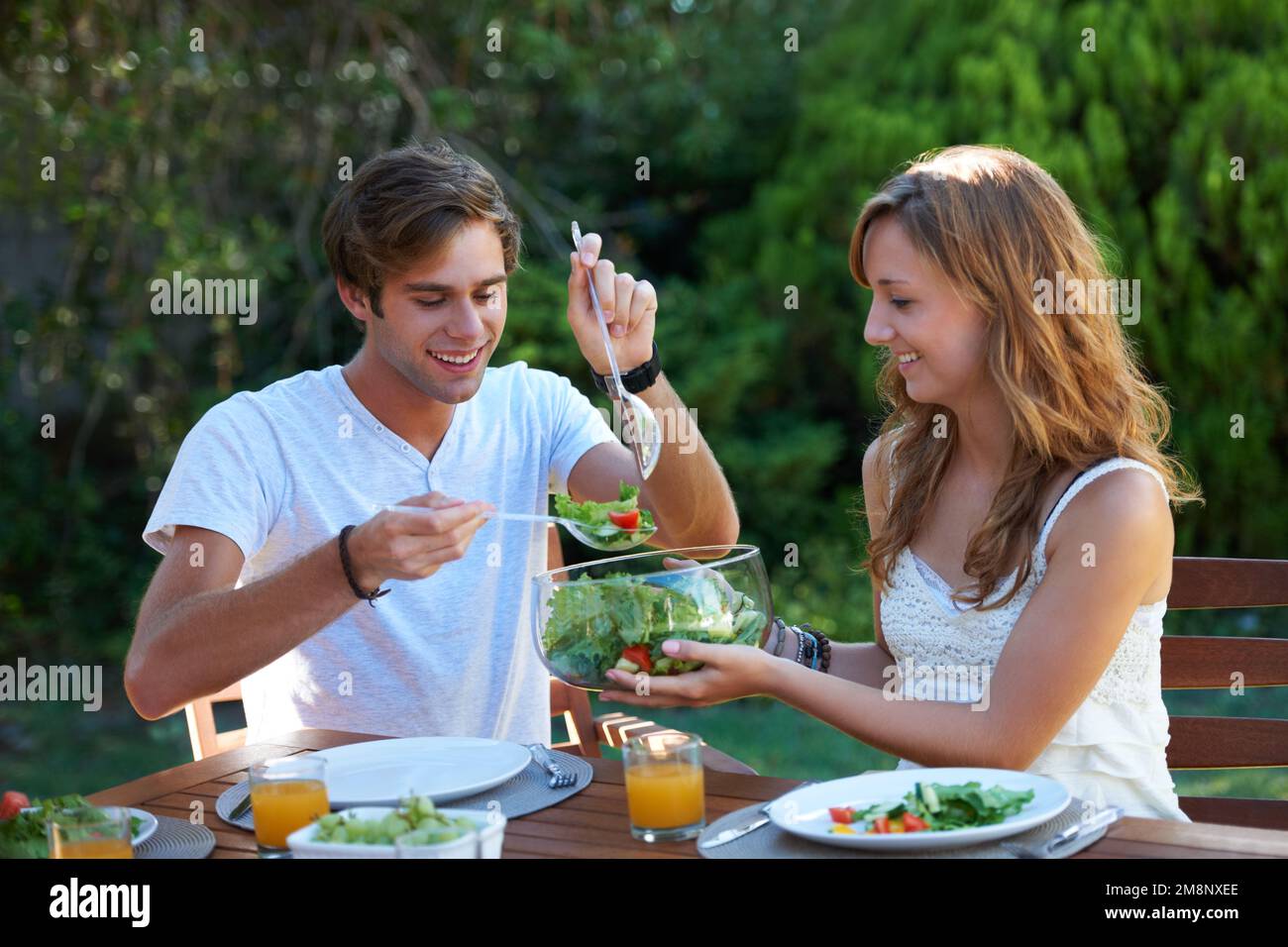Treffen gesunder Lebensmittel Entscheidungen. Ein junges Teenager-Paar, das ein gesundes Mittagessen mit ihm teilt. Stockfoto
