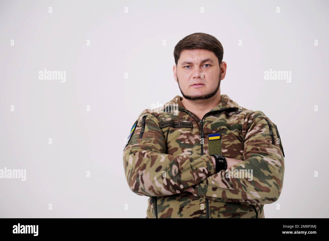 Ukrainischer Soldat in Militäruniform mit Flagge und Chevron, das ein ukrainisches Dreizack-Emblem und ein nationales Symbol in der Mitte der Standing Army Soldier Standing Armed Forces of Ukraine darstellt. Ukrainischer Soldat Stockfoto