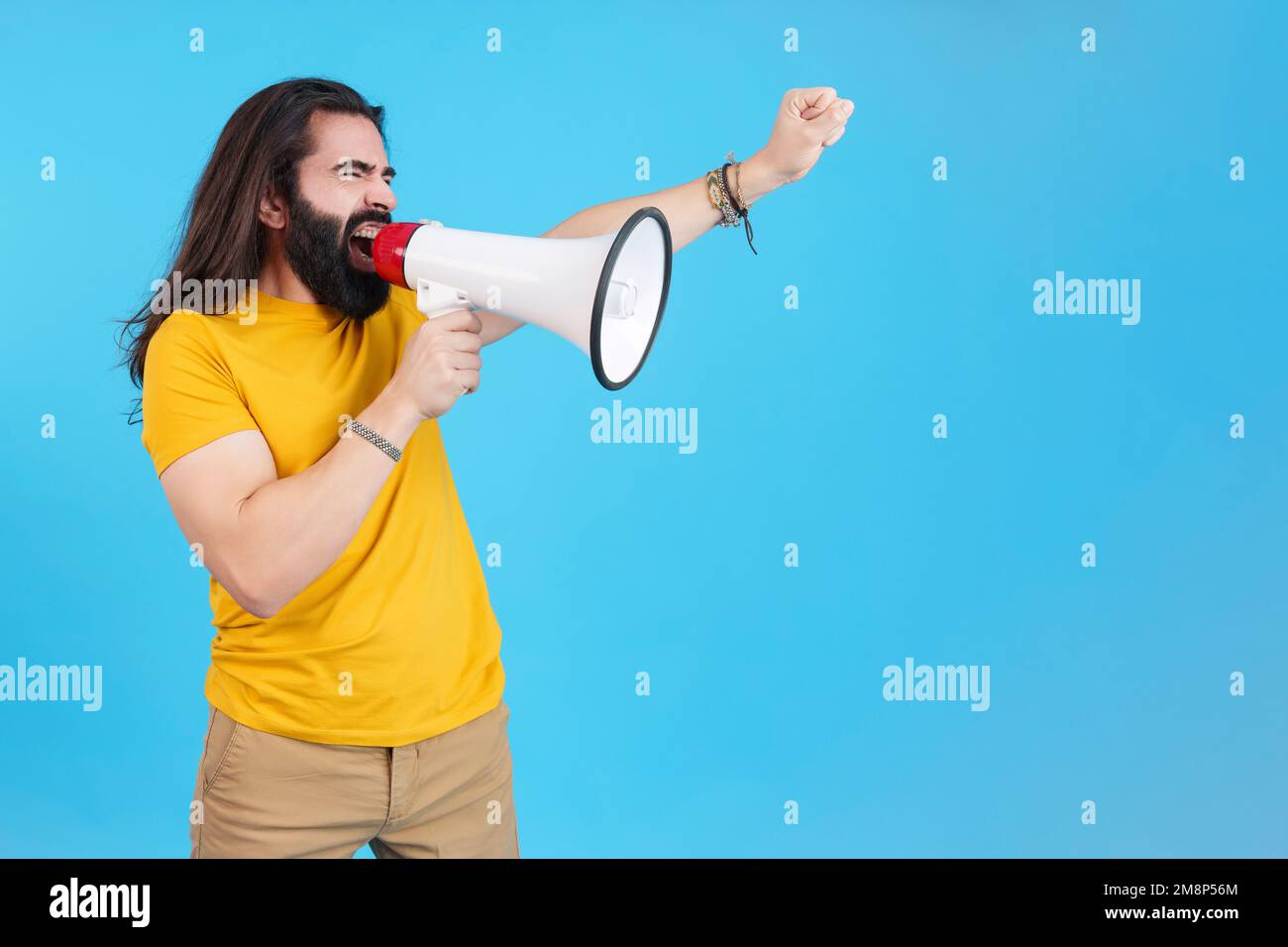 Ein Mann protestiert, während er mit einem Lautsprecher schreit Stockfoto