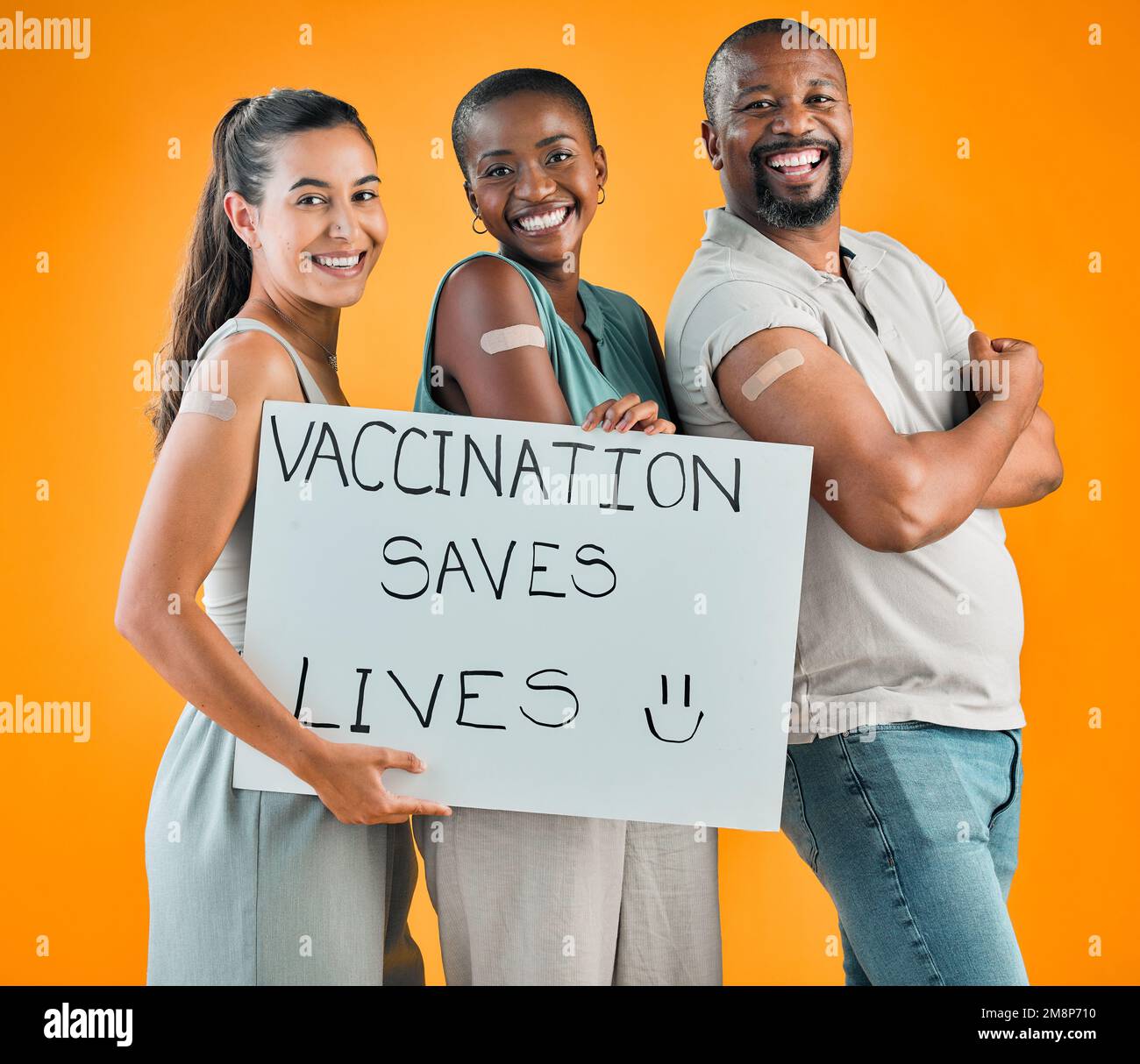 Covid-geimpfte verschiedene Personengruppen, die Poster zeigen und in der Hand halten. afroamerikanischer Mann und Frau mit gemischter Rasse, isoliert auf gelbem Studio Stockfoto