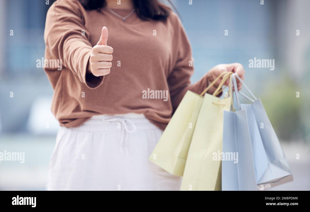 Das Beste aus jeder Situation machen. Eine Frau, die beim Einkaufen die Daumen nach oben drückt. Stockfoto