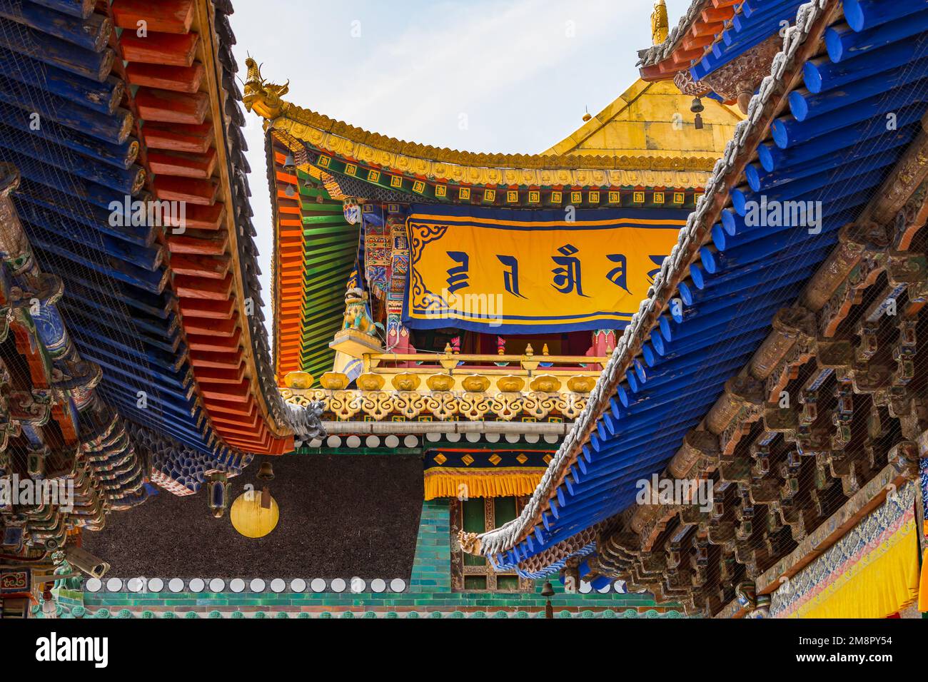 Farbenfrohe Dächer mit Balken und Ornamenten und spektakuläre Dekorationen in einem Tempel im Kumbum Jampaling Kloster, Xining, China Stockfoto