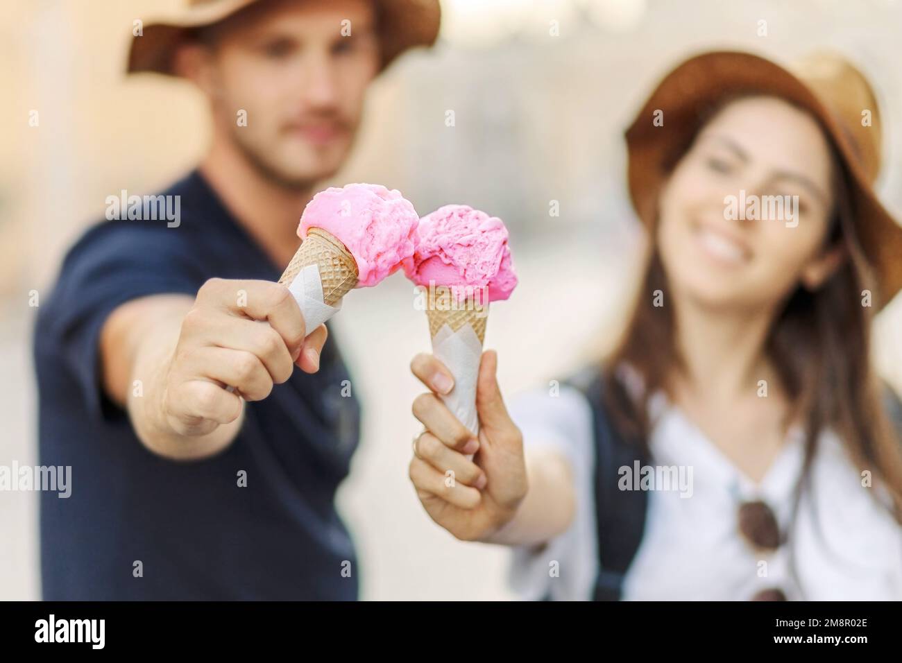 Glückliches Paar, das in Rom, Italien, Eis isst. Wunderschönes, helles Eis mit verschiedenen Geschmacksrichtungen in den Händen eines Paares Stockfoto