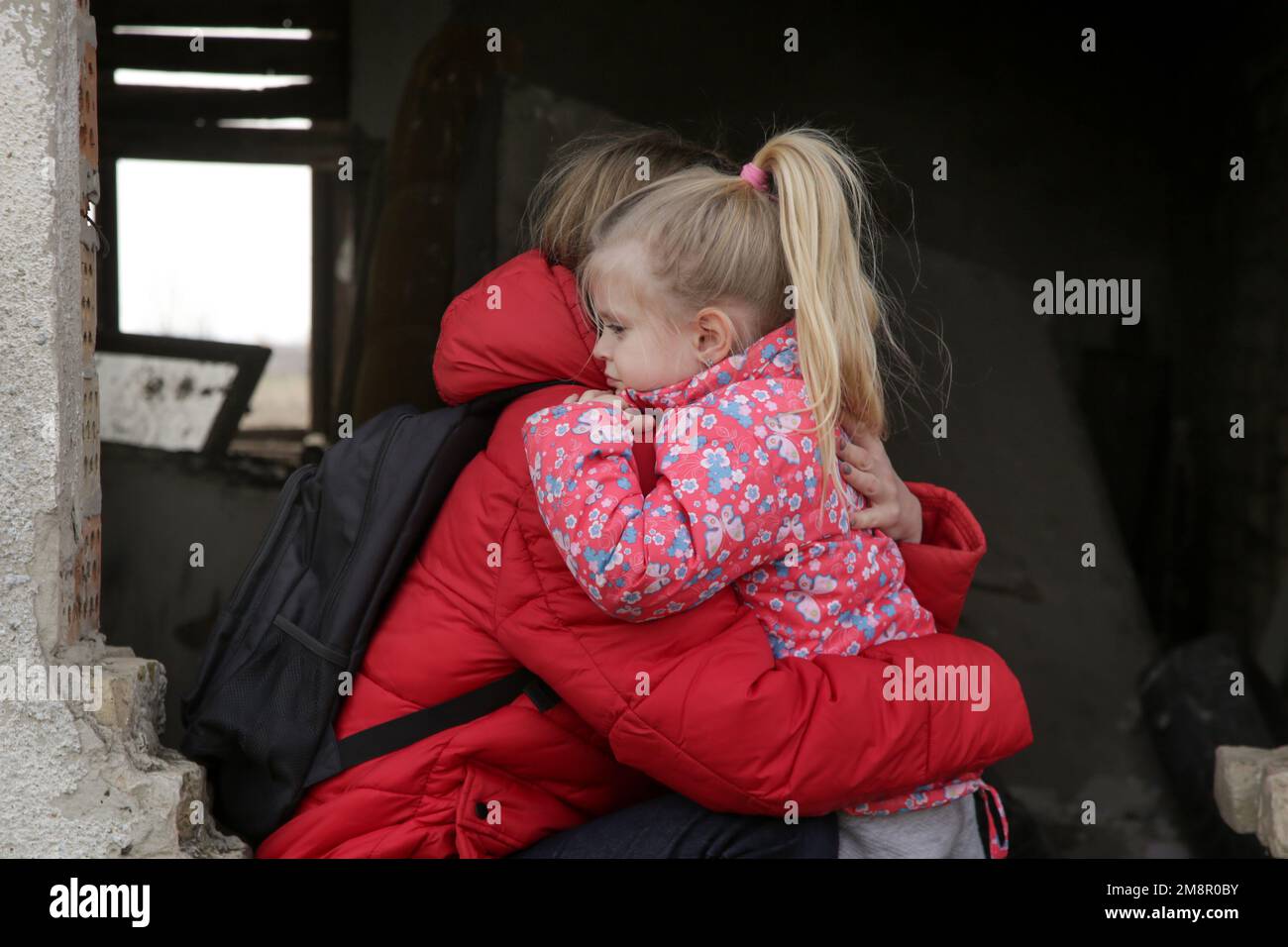 Mutter und Tochter in zerstörtem Gebäude. Krieg, Flüchtlinge, Kriegskrisenkonzept. Stockfoto