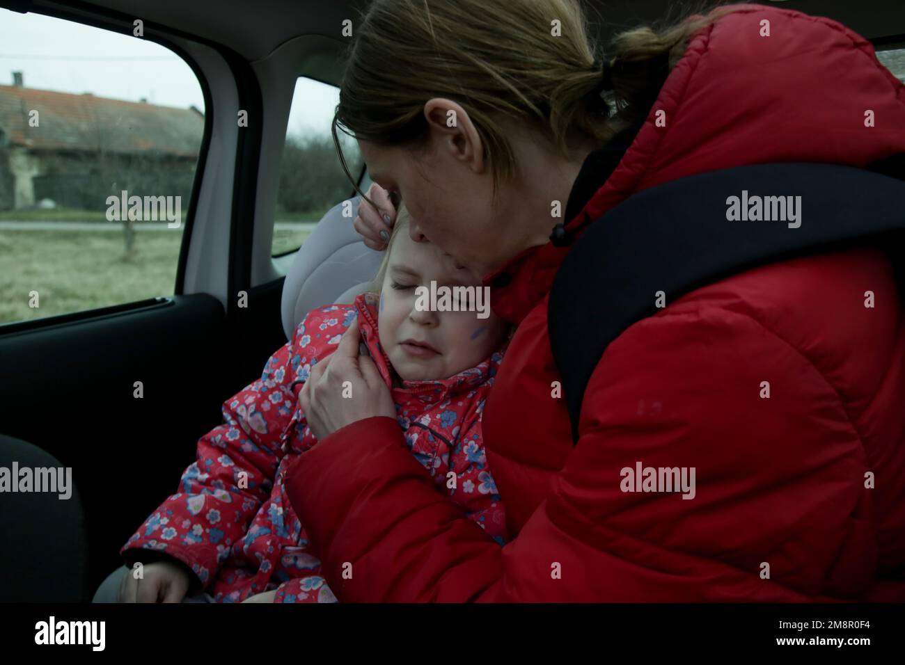Die Flüchtlinge, die vor dem Krieg fliehen. Mutter und ihre Tochter im Auto. Flüchtlinge, Kriegskrisenkonzept. Stockfoto