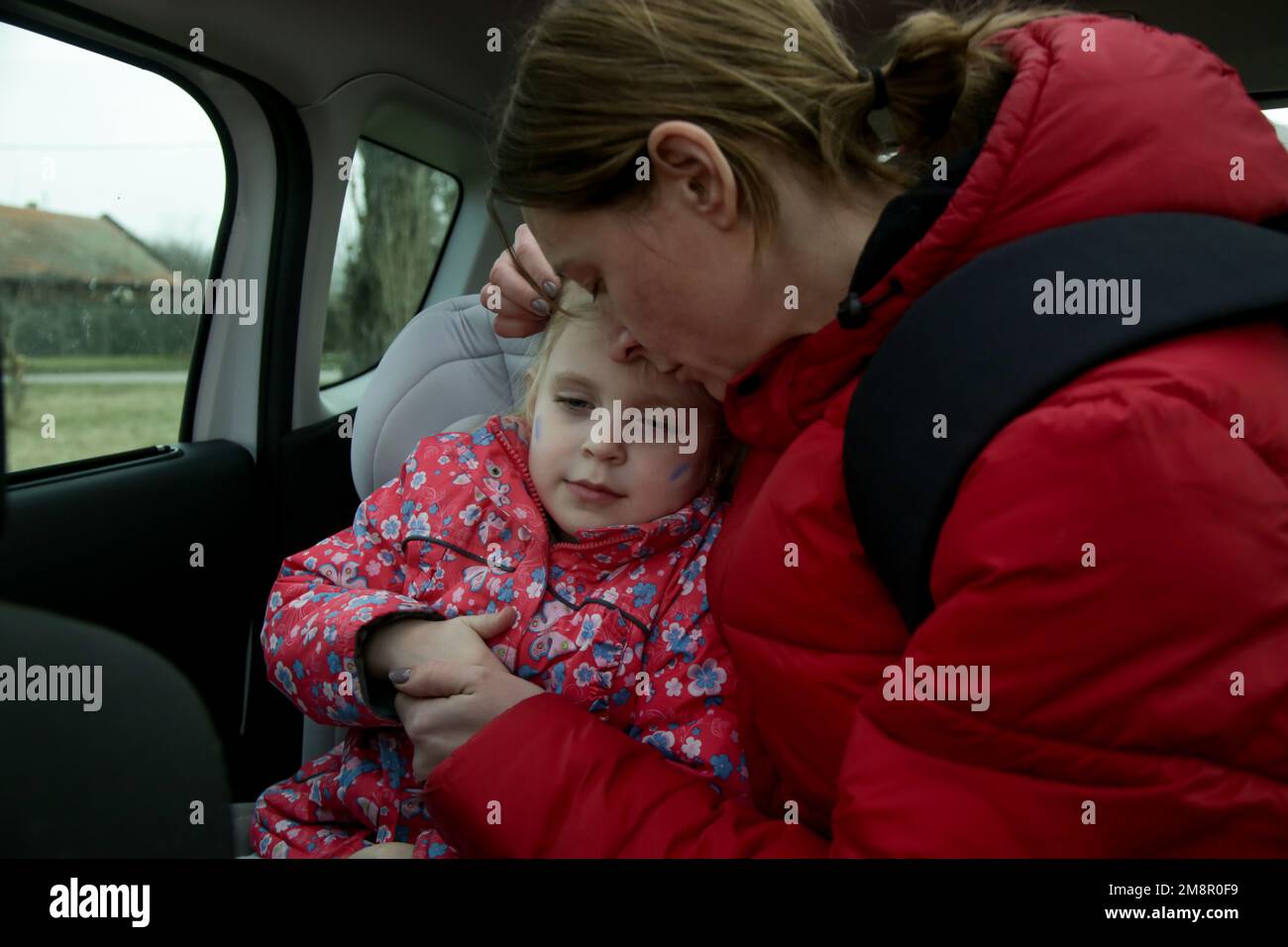 Die Flüchtlinge, die vor dem Krieg fliehen. Mutter und ihre Tochter im Auto. Flüchtlinge, Kriegskrisenkonzept. Stockfoto