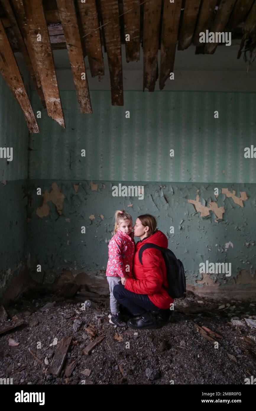 Mutter und Tochter in zerstörtem Gebäude. Krieg, Flüchtlinge, Kriegskrisenkonzept. Stockfoto