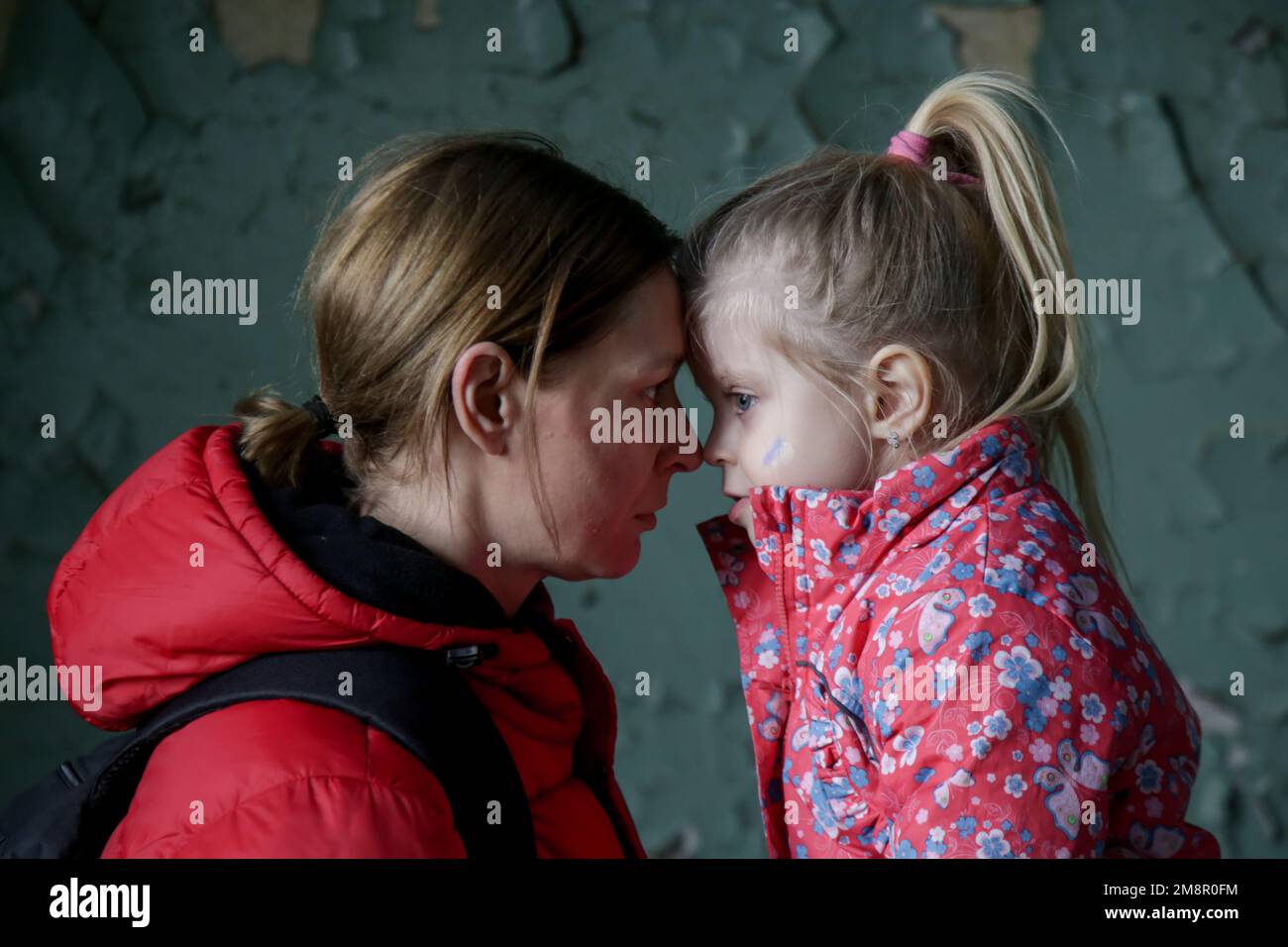 Mutter und Tochter in zerstörtem Gebäude. Krieg, Flüchtlinge, Kriegskrisenkonzept. Stockfoto