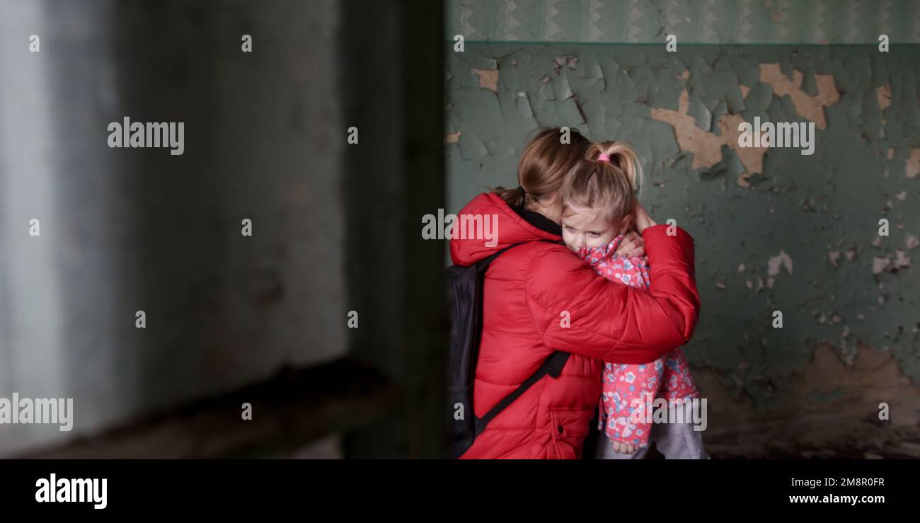 Mutter und Tochter in zerstörtem Gebäude. Krieg, Flüchtlinge, Kriegskrisenkonzept. Stockfoto