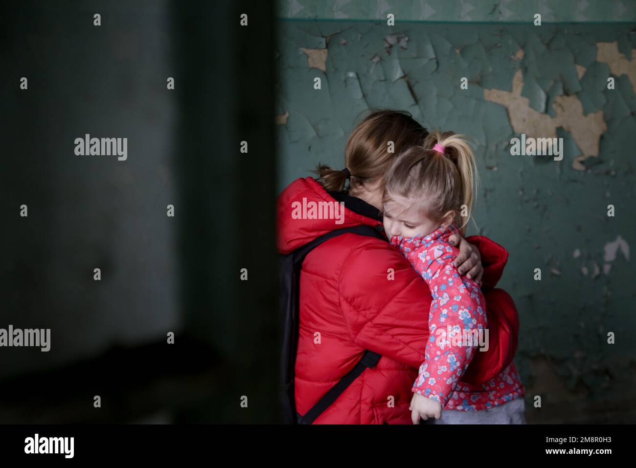 Mutter und Tochter in zerstörtem Gebäude. Krieg, Flüchtlinge, Kriegskrisenkonzept. Stockfoto