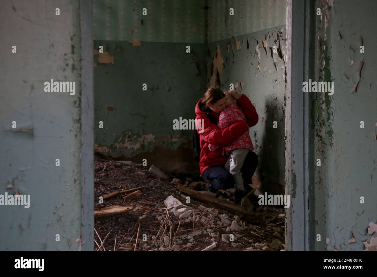 Mutter und Tochter in zerstörtem Gebäude. Krieg, Flüchtlinge, Kriegskrisenkonzept. Stockfoto