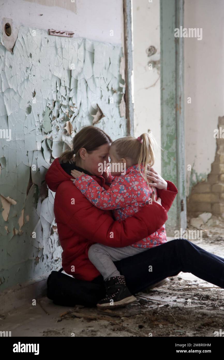 Mutter und Tochter in zerstörtem Gebäude. Krieg, Flüchtlinge, Kriegskrisenkonzept. Stockfoto