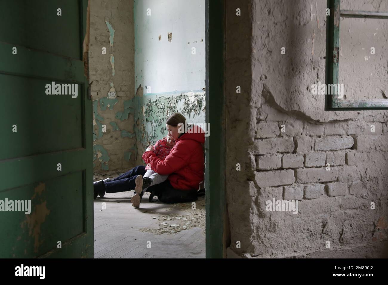 Mutter und Tochter in zerstörtem Gebäude. Krieg, Flüchtlinge, Kriegskrisenkonzept. Stockfoto