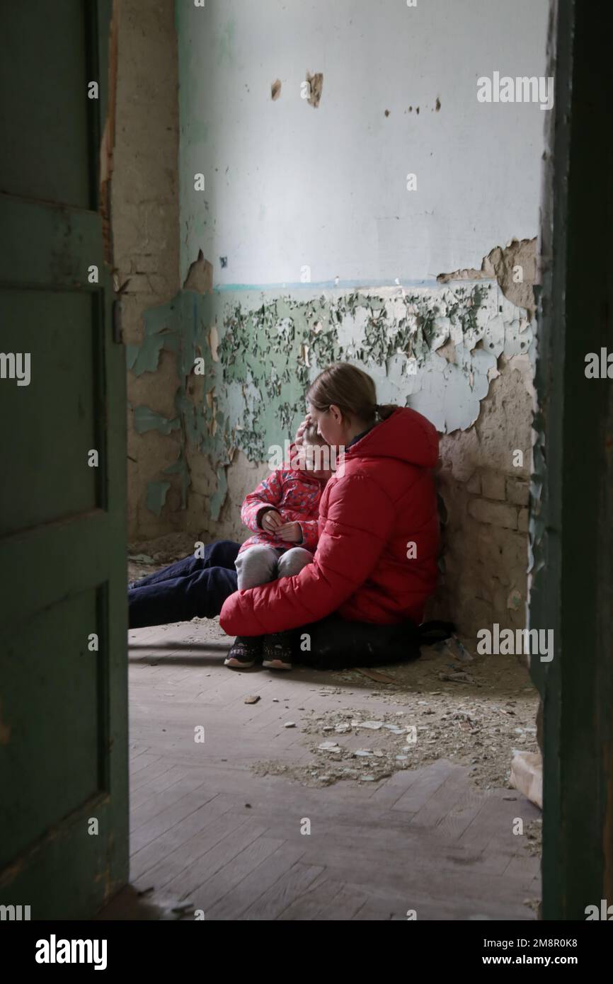 Mutter und Tochter in zerstörtem Gebäude. Krieg, Flüchtlinge, Kriegskrisenkonzept. Stockfoto