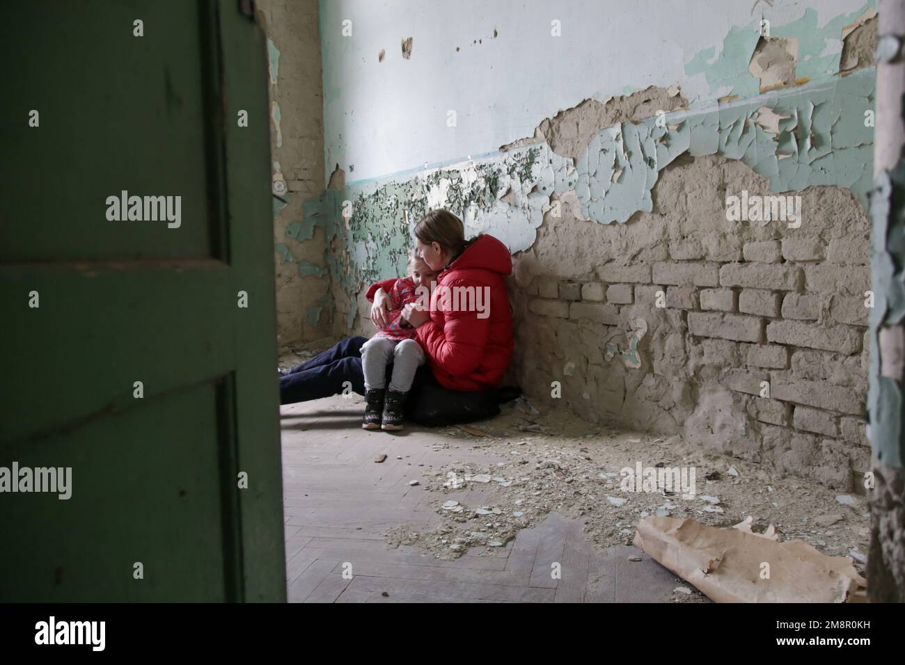 Mutter und Tochter in zerstörtem Gebäude. Krieg, Flüchtlinge, Kriegskrisenkonzept. Stockfoto