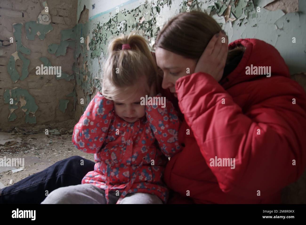 Mutter und Tochter in zerstörtem Gebäude. Krieg, Flüchtlinge, Kriegskrisenkonzept. Stockfoto