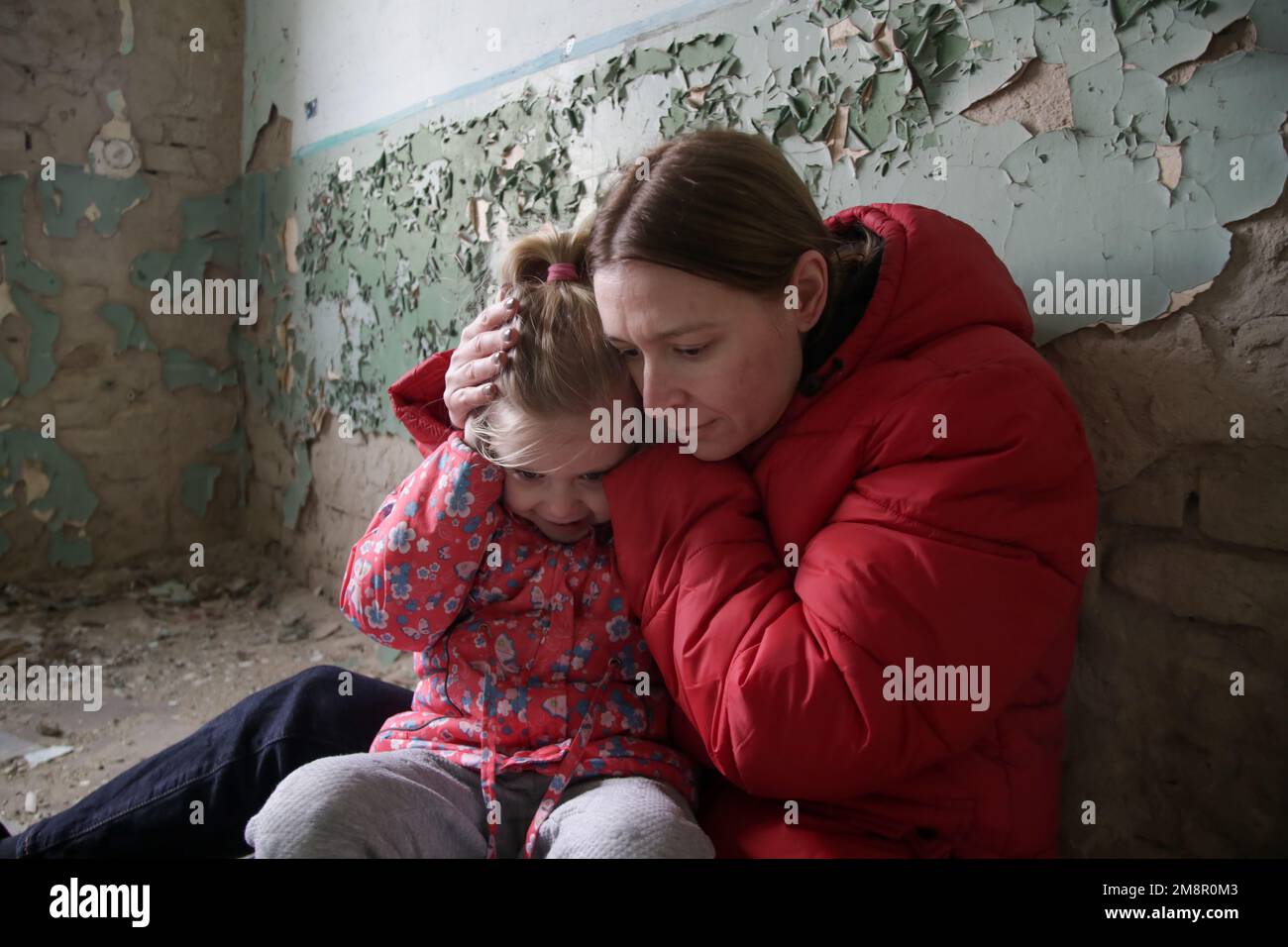 Mutter und Tochter in zerstörtem Gebäude. Krieg, Flüchtlinge, Kriegskrisenkonzept. Stockfoto