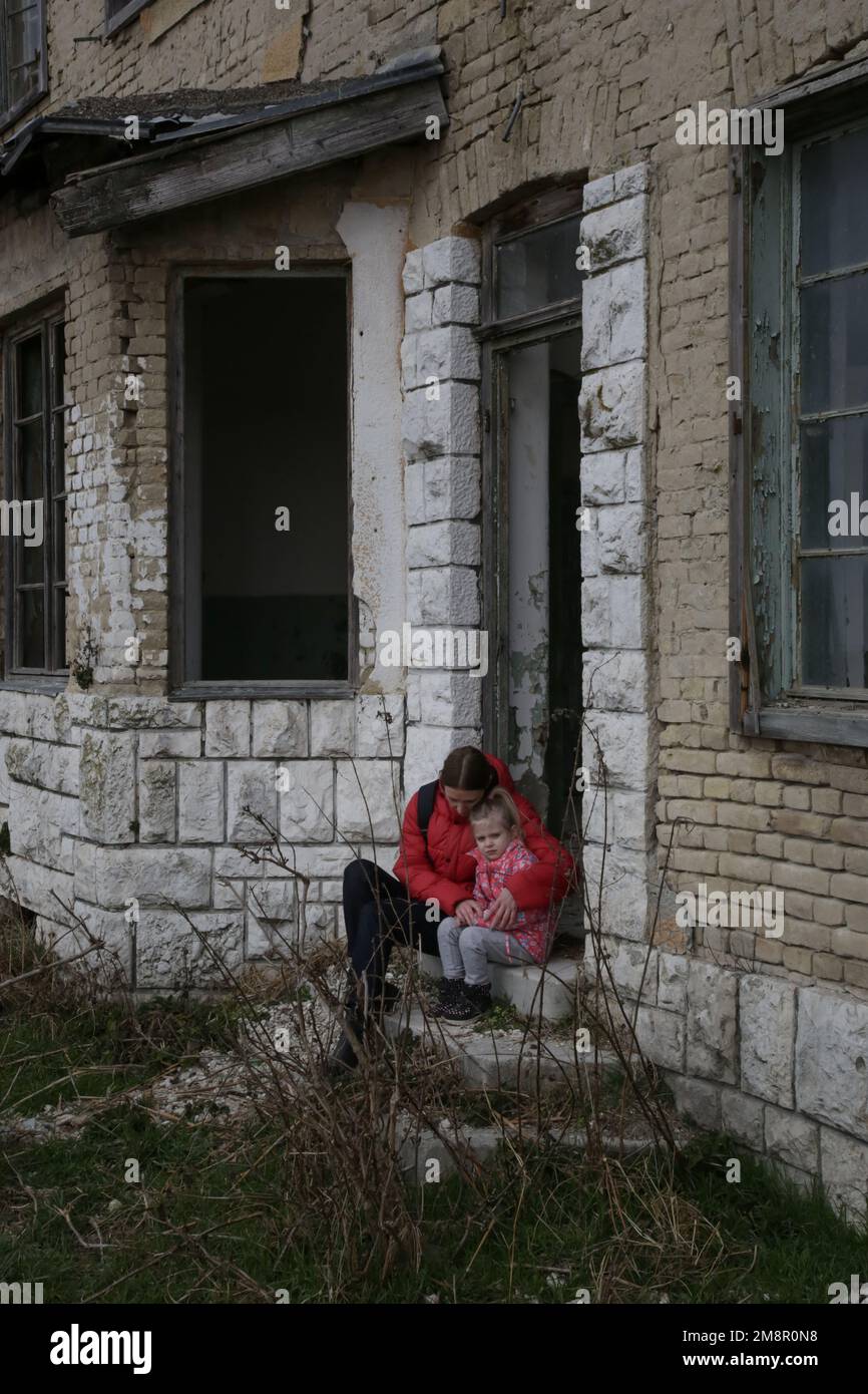 Mutter und Tochter in zerstörtem Gebäude. Krieg, Flüchtlinge, Kriegskrisenkonzept. Stockfoto