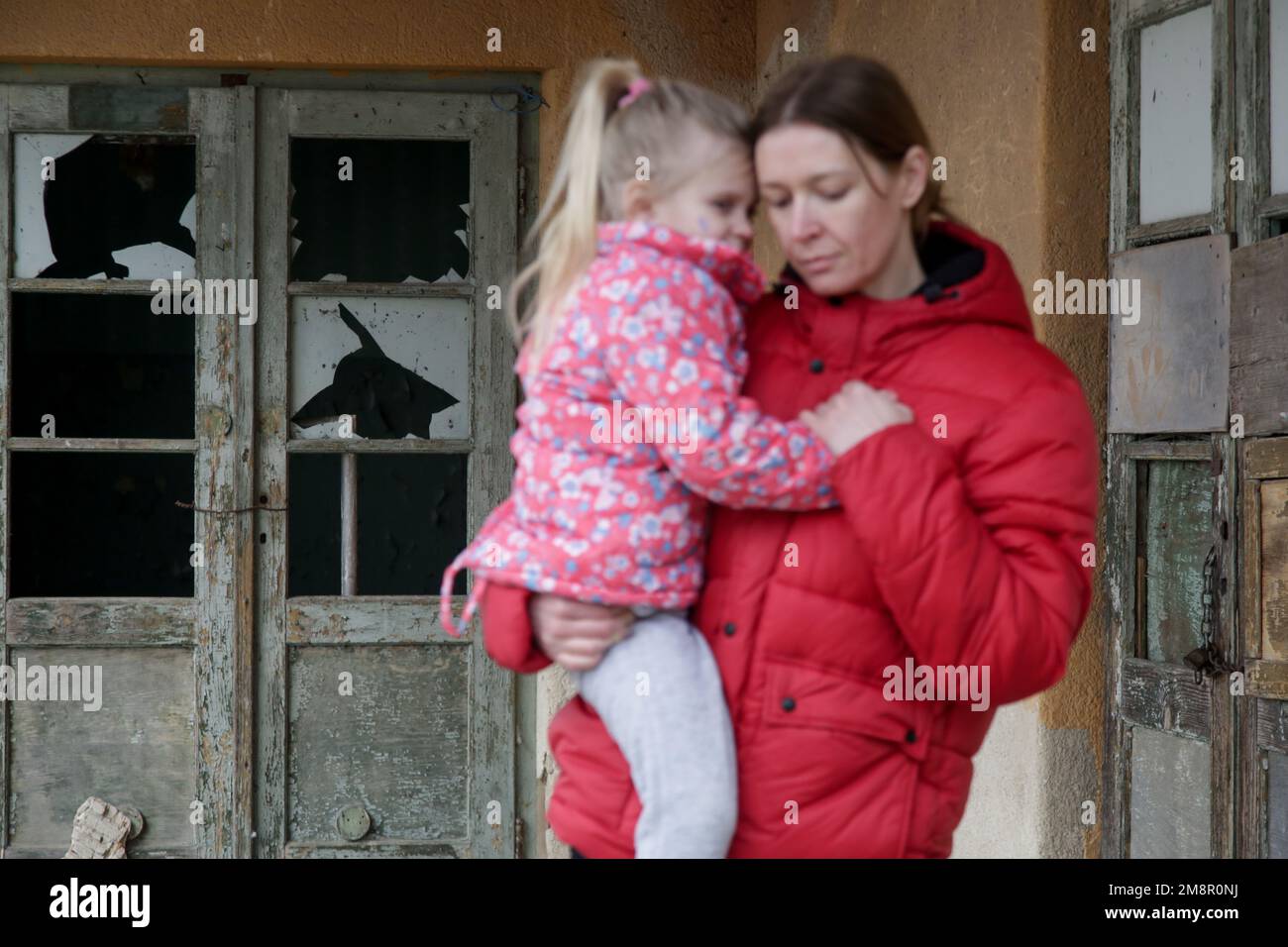 Mutter und Tochter in zerstörtem Gebäude. Krieg, Flüchtlinge, Kriegskrisenkonzept. Stockfoto