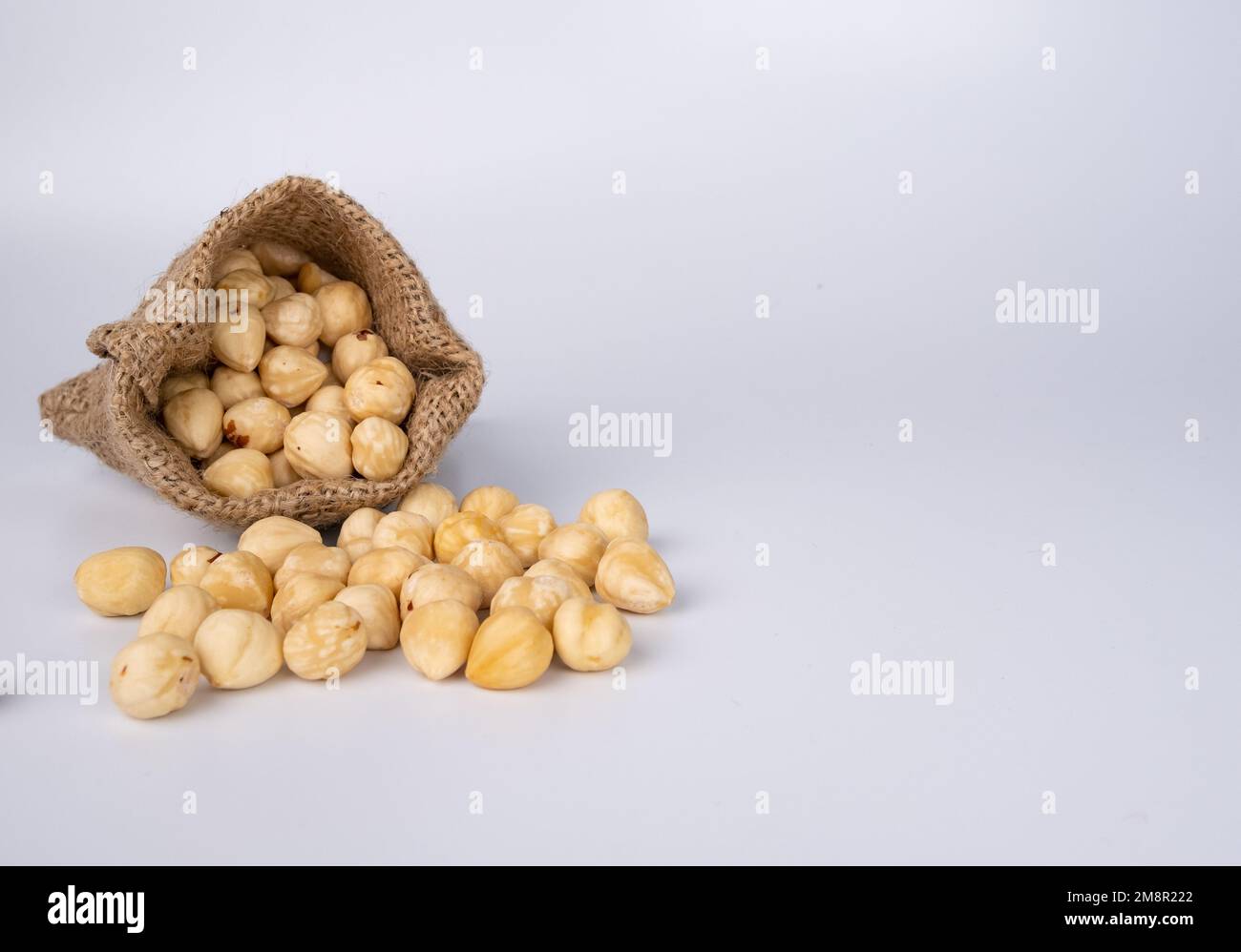 Nüsse in einem Stoffsack auf weißem Hintergrund. Stockfoto