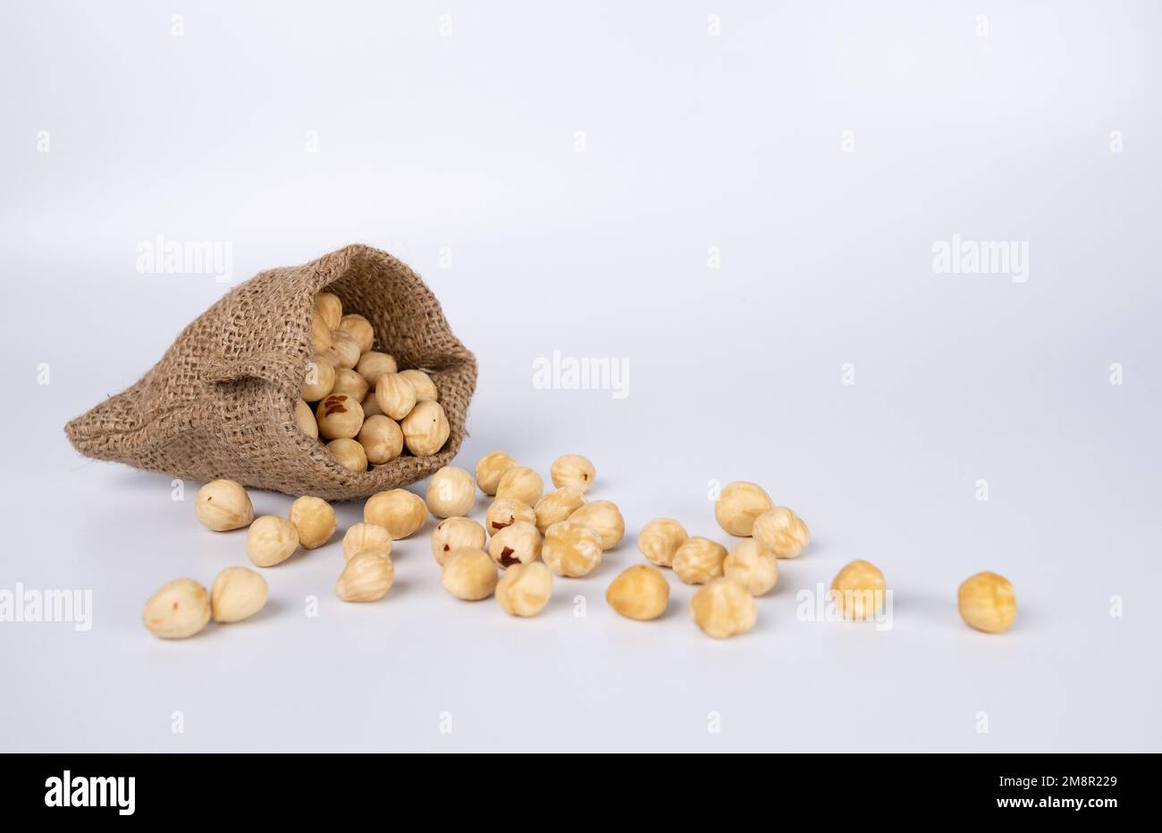 Nüsse in einem Stoffsack auf weißem Hintergrund. Stockfoto