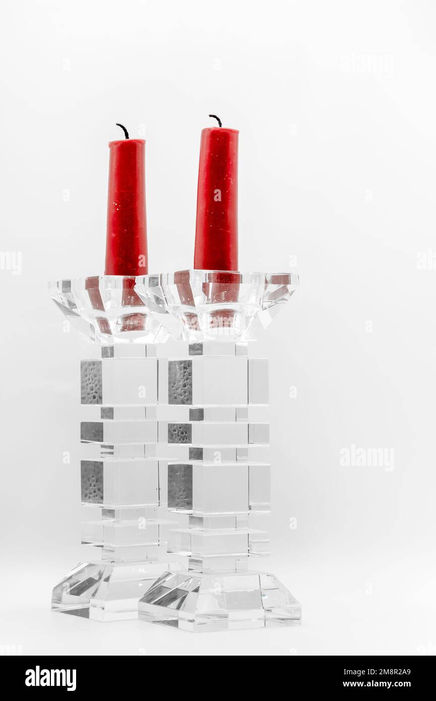 Nahaufnahme von zwei roten Kerzen in durchsichtigen, glasgeformten Kerzenhaltern Stockfoto