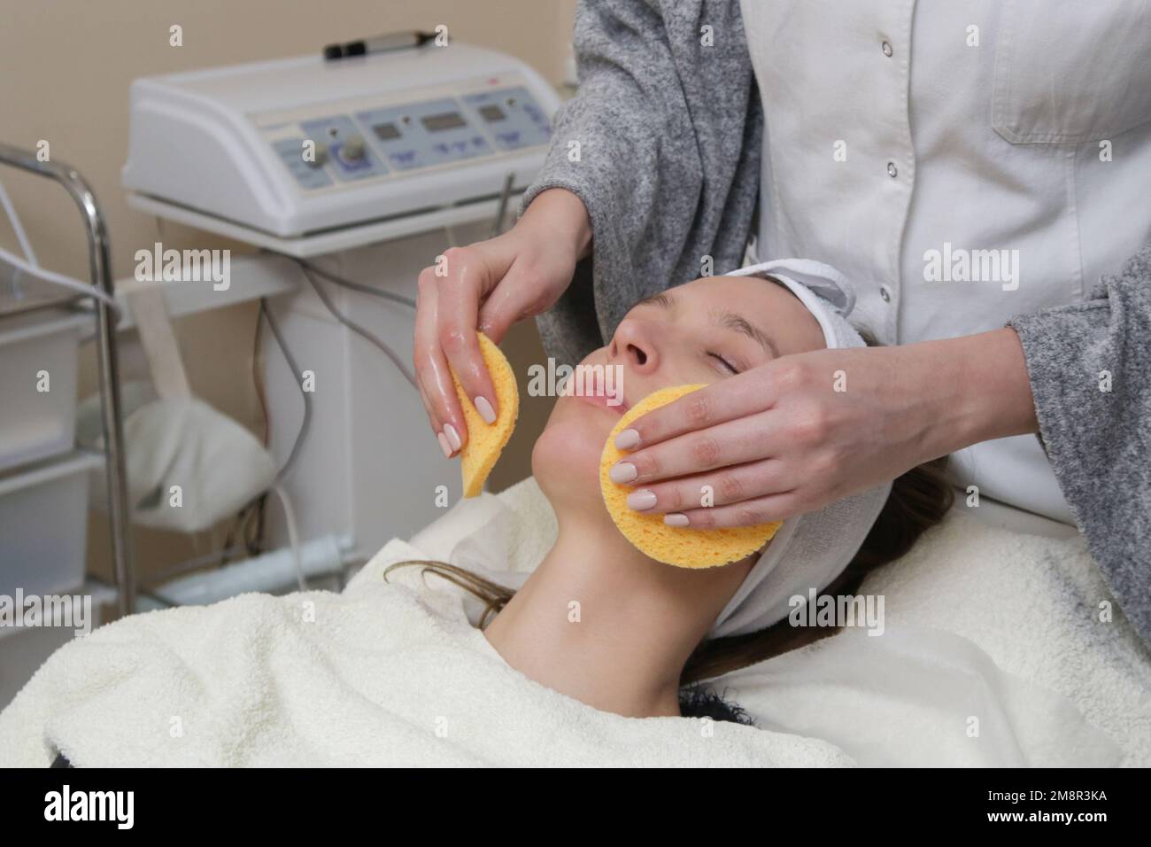 Dermatologe bereitet die Gesichtshaut der Frau für die Behandlung vor. Reinigungs-, Peeling- und Peeling-Prozess. Stockfoto