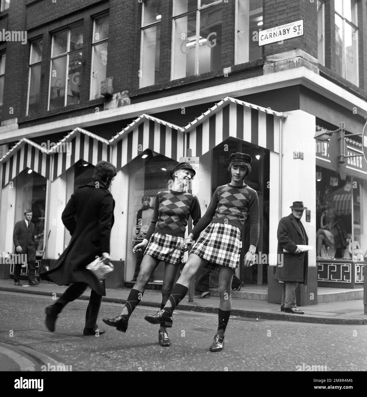 Ein Mann und eine Frau, die sich in identischen Outfits aus Pullover und Rock in der modischen Carnaby Street, London 1968, posieren. Foto von Tony Henshaw Archive Stockfoto