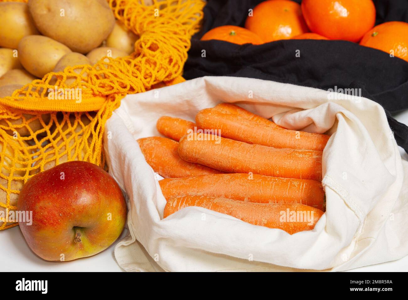 Frisches Gemüse und Obst. Wiederverwendbare Einkaufstaschen. Stoffbeutel, Netzbeutel, Schnürbeutel. Gefüllt mit Gemüse und Obst. Orangen. Karotten-Nahaufnahme Stockfoto